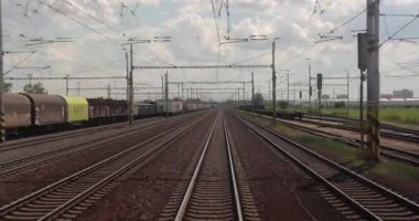 Breclav, Çek Cumhuriyeti - 15 Mayıs 2024: Sürücülerin bakış açısından tren yolculuğu bakış açısı, kabin manzarası yük vagonları ile demiryolu sahasında yuvarlanıyor