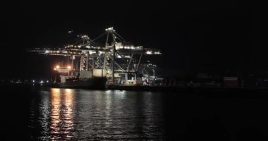 Rotterdam, Hollanda - 12 Şubat 2023: Kargo konteynır terminali gece Rotterdam limanında, Maasvlakte limanında yüklenmiş büyük konteyner gemileri karanlıkta