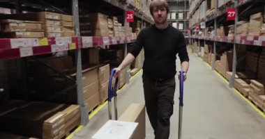 Depo rafları karton kutularla dolu, lojistik merkezi, el arabası ve ürünlerle dolu.