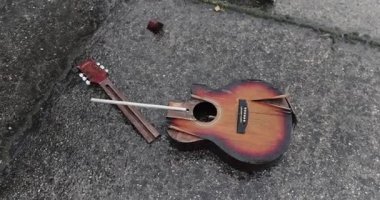 Karlı yağmurda yere düşen kırık bir gitar. Öfke, çalma ve parçalanmış enstrümandan sonra sona erdi.
