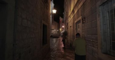 Kotor, Montenegro - July 26, 2024: Walking in Kotor old medieval town center, tourist destination with spectacular stone building architecture and cobble streets, narrow alleys in the evening
