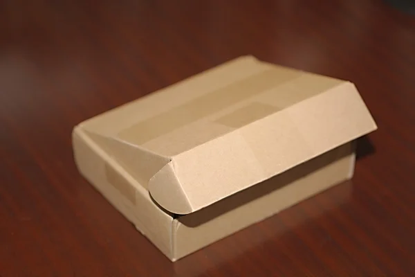 Caja de cartón en el escritorio — Foto de Stock