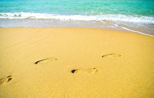 Footprints on the beach sand by the sea — Stock Photo, Image