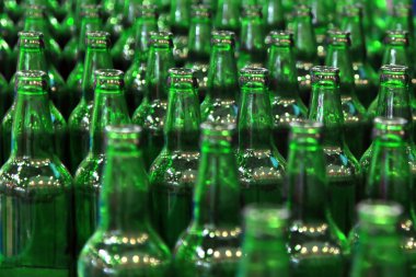 Fabrikada taşıma bandında bir sürü şişe var.