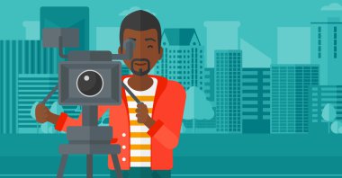 Cameraman with movie camera on a tripod.