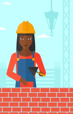 Duvarcı ustası spatula ve tuğla ile.