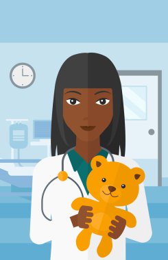 Çocuk doktoru holding oyuncak ayı.