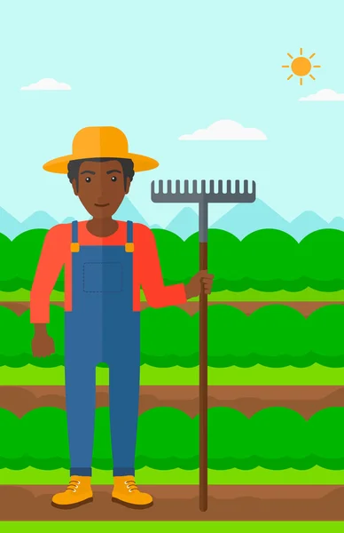 Agricultor con rastrillo . — Vector de stock