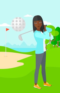 golf oyuncusu topa vuruyor.