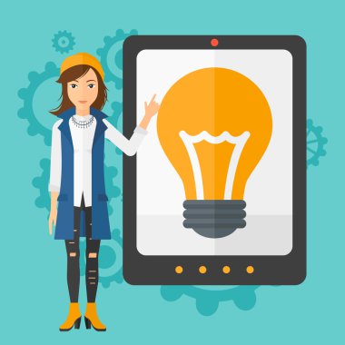 Woman pointing at tablet computer with light bulb on screen.