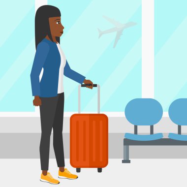 Woman at airport with suitcase.