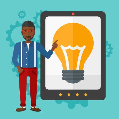 Man pointing at tablet computer with light bulb on screen.