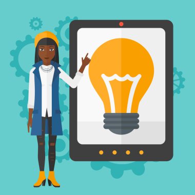 Woman pointing at tablet computer with light bulb on screen.