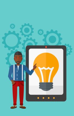 Man pointing at tablet computer with light bulb on screen.