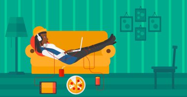 Birçok gadget'lar ile kanepede yatan kadın.