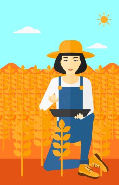 Woman with tablet computer on field.