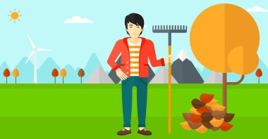 Komisyon duran ağaç ve sonbahar yaprak yığını yakın olan adam.