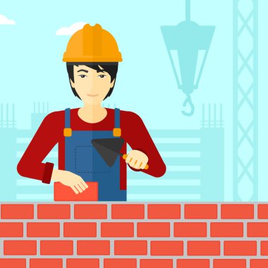 Duvarcı ustası spatula ve tuğla ile.