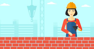 Duvarcı ustası spatula ve tuğla ile.