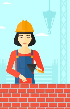 Duvarcı ustası spatula ve tuğla ile.