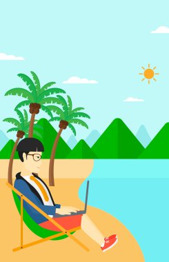 Şezlong dizüstü bilgisayar ile oturan işadamı.