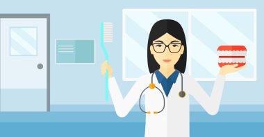 Dişçi diş çene modeli ve diş fırçası.