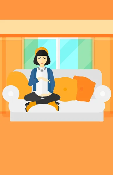 Gravid kvinna som sitter på soffan. — Stock vektor