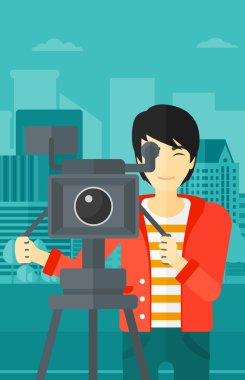 Cameraman with movie camera on a tripod.