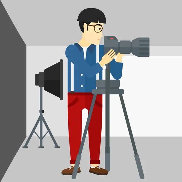 Photographer working with camera on a tripod. — Stockvector