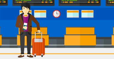 Man standing with suitcase and holding ticket.