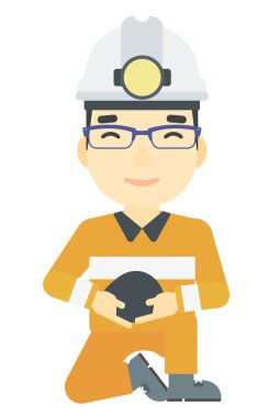 Madenci holding kömür elinde.