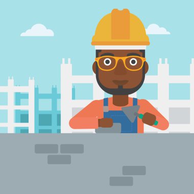 Duvarcı ustası spatula ve tuğla ile.