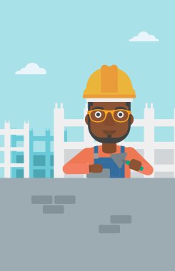 Duvarcı ustası spatula ve tuğla ile.