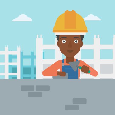 Duvarcı ustası spatula ve tuğla ile.