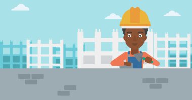 Duvarcı ustası spatula ve tuğla ile.