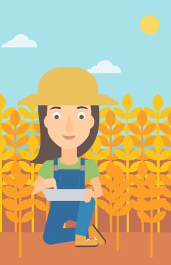 Woman with tablet computer on field.