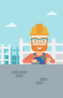 Duvarcı ustası spatula ve tuğla ile.