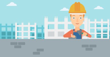 Duvarcı ustası spatula ve tuğla ile.