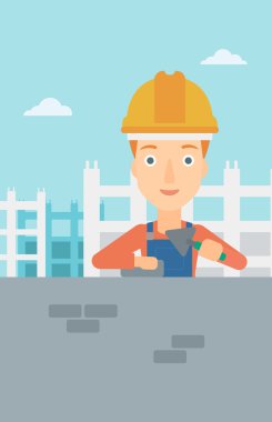 Duvarcı ustası spatula ve tuğla ile.