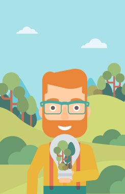 Adam ampul ve ağaçlar içinde.