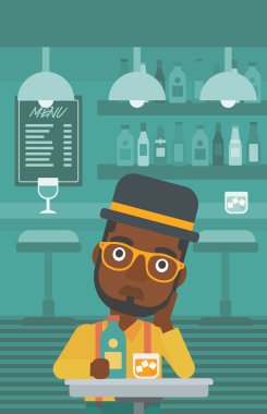 Şişe ve cam ile üzgün adam.