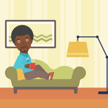 Bardak çay ile yatan adam.