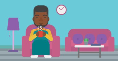 Çay sandalyeyle içinde oturan adam.