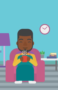 Çay sandalyeyle içinde oturan adam.