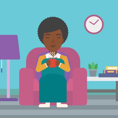 Woman sitting in chair with cup of tea.