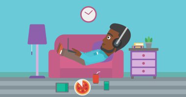 Birçok gadget'lar ile kanepede yatan adam.