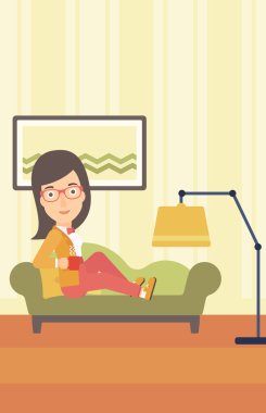 Woman lying with cup of tea.