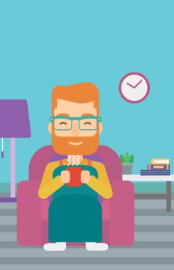 Çay sandalyeyle içinde oturan adam.