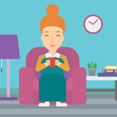 Woman sitting in chair with cup of tea.