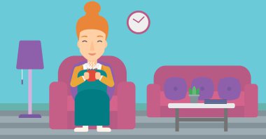 Woman sitting in chair with cup of tea.